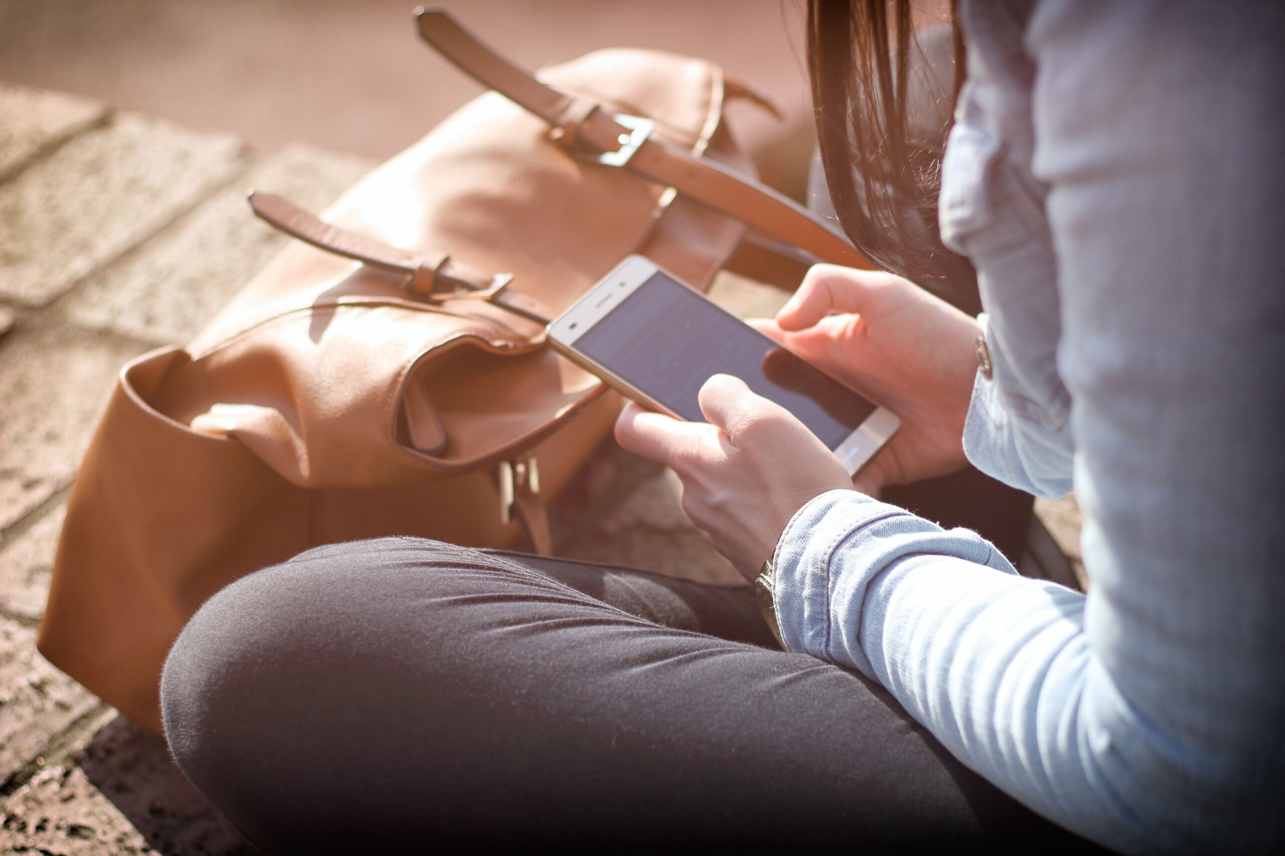 Bir kadın açık havada akıllı telefon uygulamasını kontrol ediyor