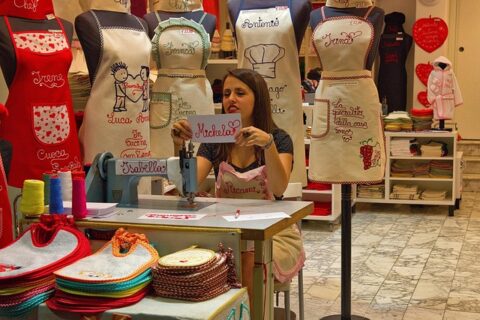 El emeğiyle ürün üreten bir kadın girişimci, tezgahında kişiye özel işlemeli ürünler hazırlıyor